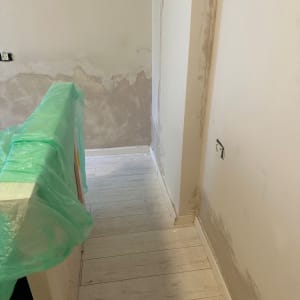 קיר עם טיח מתקלף ויריעת פלסטיק ירוקה