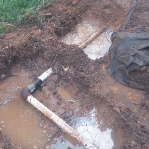 צינור שבור באדמה עם מים מסביב