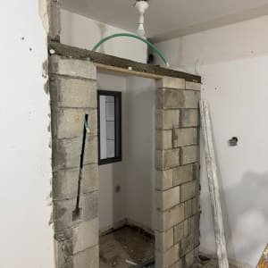 קיר בלוקים בבנייה עם צינור ירוק ותאורה