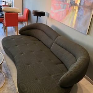 ספה מעוצבת בחדר עם כיסאות אדומים ותמונה צבעונית