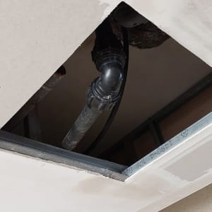 תקרת גבס עם פתח חשוף וצינורות גלויים