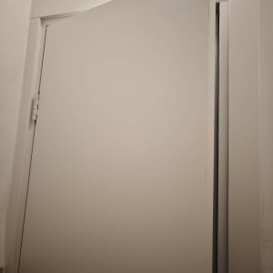 דלת לבנה פתוחה חלקית עם מסגרת פשוטה