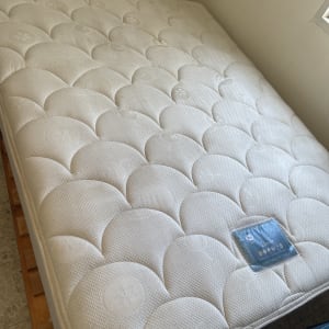 מזרן לבן נקי על מיטה מעץ