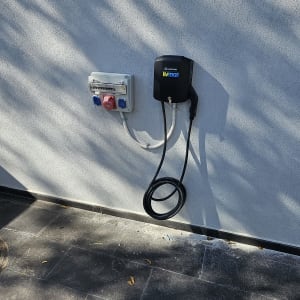 עמדת טעינה לרכב חשמלי עם כבלים על קיר חיצוני