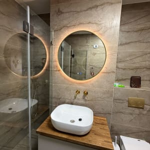 כיור לבן על משטח עץ עם ברזים מוזהבים