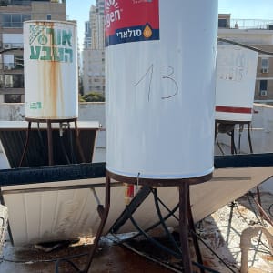 דודי שמש על גג בניין עם צנרת וחיבורים