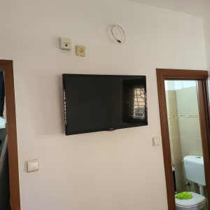 טלוויזיה תלויה על קיר עם שקעים וכבלים