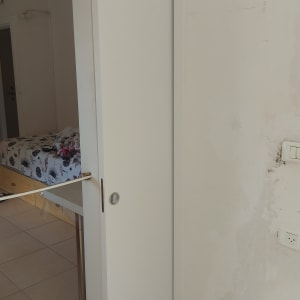 דלת הזזה לבנה בחדר עם קיר לבן