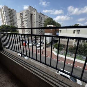 מעקה ברזל במרפסת עם נוף לבניינים