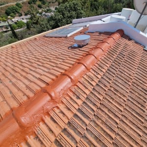 רעפים כתומים על גג עם ציפוי אטימה אדום