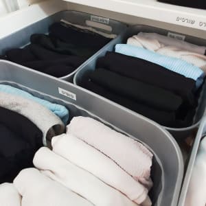 בגדים מקופלים בתיבות אחסון מסודרות בארון