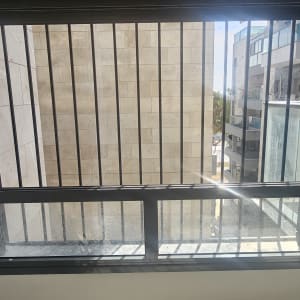 חלון עם סורגים ומסגרת מתכת שחורה