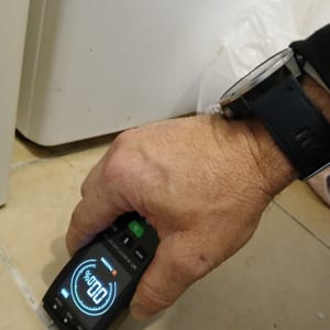 מד לחות דיגיטלי על רצפה ליד מכשיר חשמלי