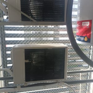 יחידות מיזוג אוויר עם רשת הגנה על רקע גדר רשת