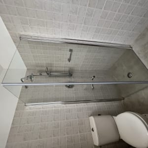 מקלחת עם דלת זכוכית וברז מתכת