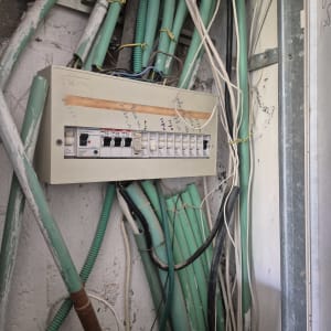לוח חשמל עם חוטים ירוקים וקירות חשופים