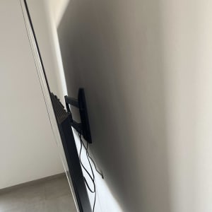 טלוויזיה מותקנת על קיר עם כבלים גלויים