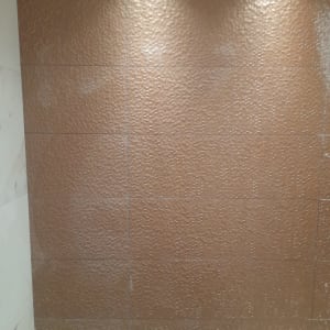 קיר אריחים חום עם סימני לכלוך או כתמים