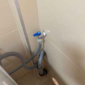 צינור מים עם ברז כחול בקיר חדר אמבטיה