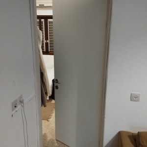 דלת לבנה פתוחה למחצה עם ידית מתכת