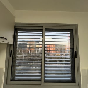 חלון עם תריסים נוף עירוני ברקע