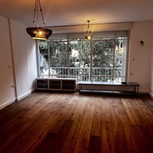 חדר ריק עם רצפת עץ ונברשות תלויות