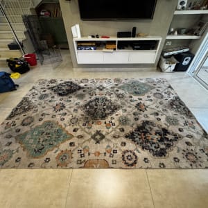 שטיח מעוצב על רצפת קרמיקה עם ציוד ניקוי בצד