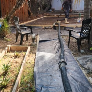 אדם עובד על יציקת בטון עם צינור גדול בחצר