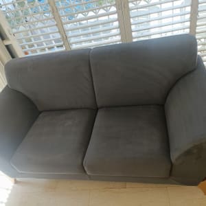 ספה אפורה ליד חלון עם תריסים