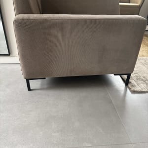 ספה חומה על רצפת אריחים אפורה