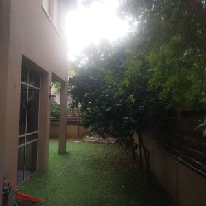 חצר עם דשא סינתטי וצינור השקיה