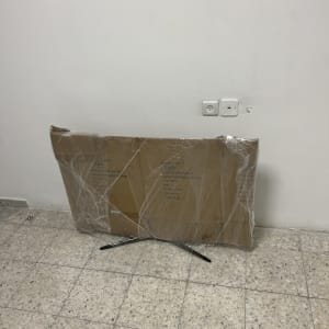 קופסה עטופה בניילון על רצפה ליד קיר