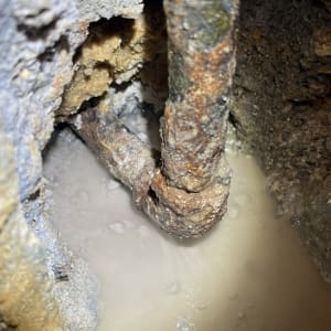 צינור חלוד עם נזילה בתוך קיר