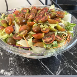 סלט ירקות עם עגבניות שרי וחסה בקערה שקופה