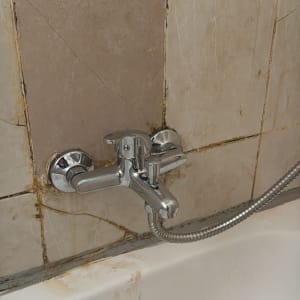 ברז אמבטיה עם אריחים ישנים ומלוכלכים