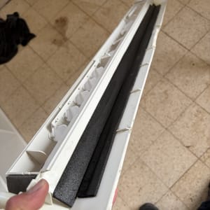 חלק ממזגן על רצפה עם יד אוחזת