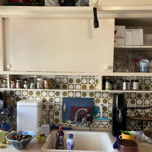 מדפים עם כוסות, צנצנות תבלינים, ומכונת סודה במטבח