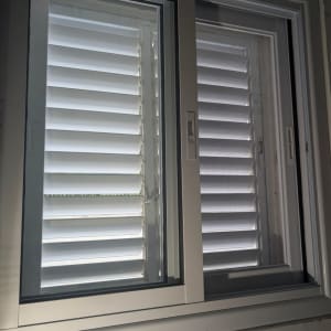 חלון אלומיניום עם תריסים לבנים