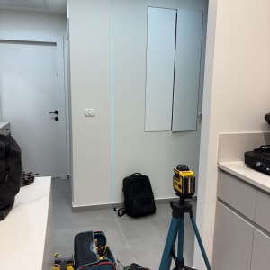 כלי עבודה ותיקי כלים בחדר, כולל חצובה ומד לייזר.