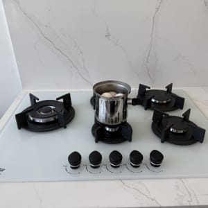 כיריים גז עם סיר מתכת וביצים רותחות