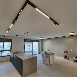התקנת גופי תאורה מעוצבים ופסי צבירה מודרניים בתקרת הבית