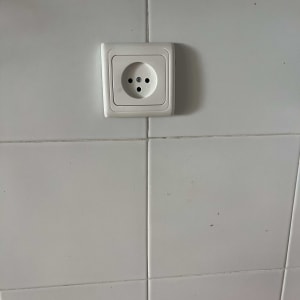 שקע חשמלי על קיר עם אריחים לבנים