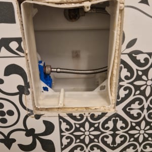 תמונה של חיבור צנרת בקיר עם אריחים דקורטיביים