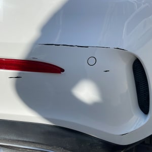 שריטות על פגוש אחורי של רכב לבן