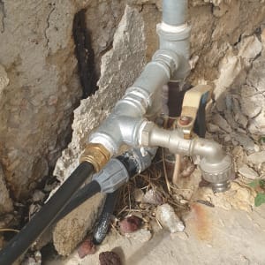 צינורות מתכת וברז מים מחוברים לקיר