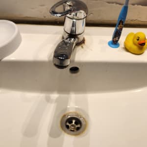 כיור עם ברז, מברשת שיניים וברווז גומי