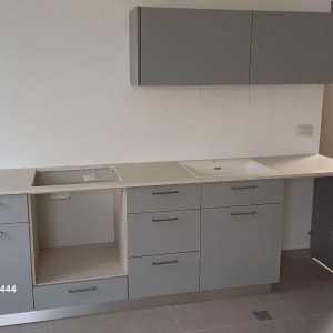 ארונות מטבח אפורים עם כיור ומשטח עבודה