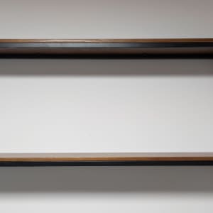 מדפים מעץ עם תומכים ממתכת על קיר לבן