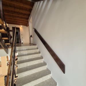 מדרגות עם מעקה עץ וקיר צבוע