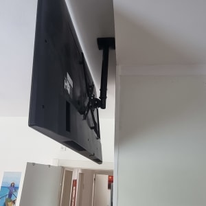 טלוויזיה מותקנת על זרוע מתכווננת על קיר